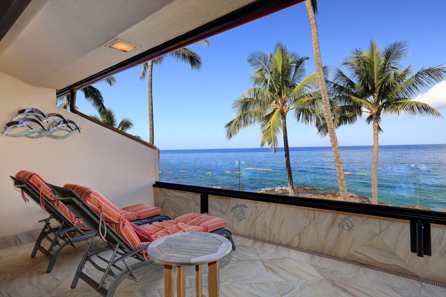 Two lounge chairs on the lanai facing the water