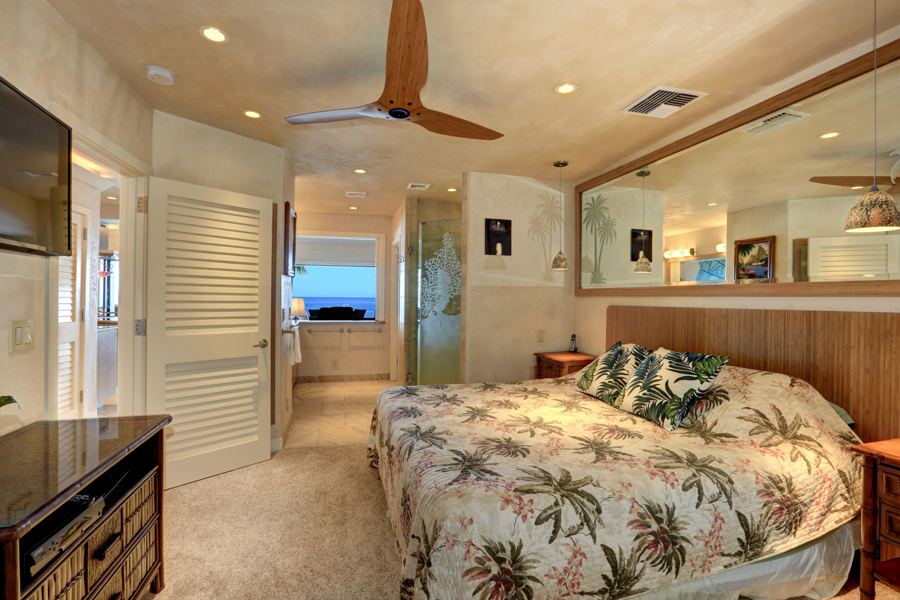 Main bedroom with king bed and ocean-view slider window